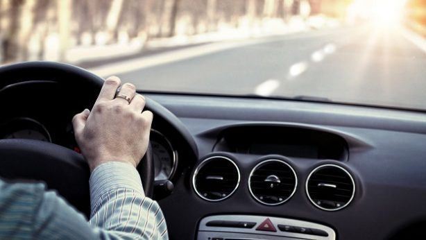 lady driving on open road with sunset